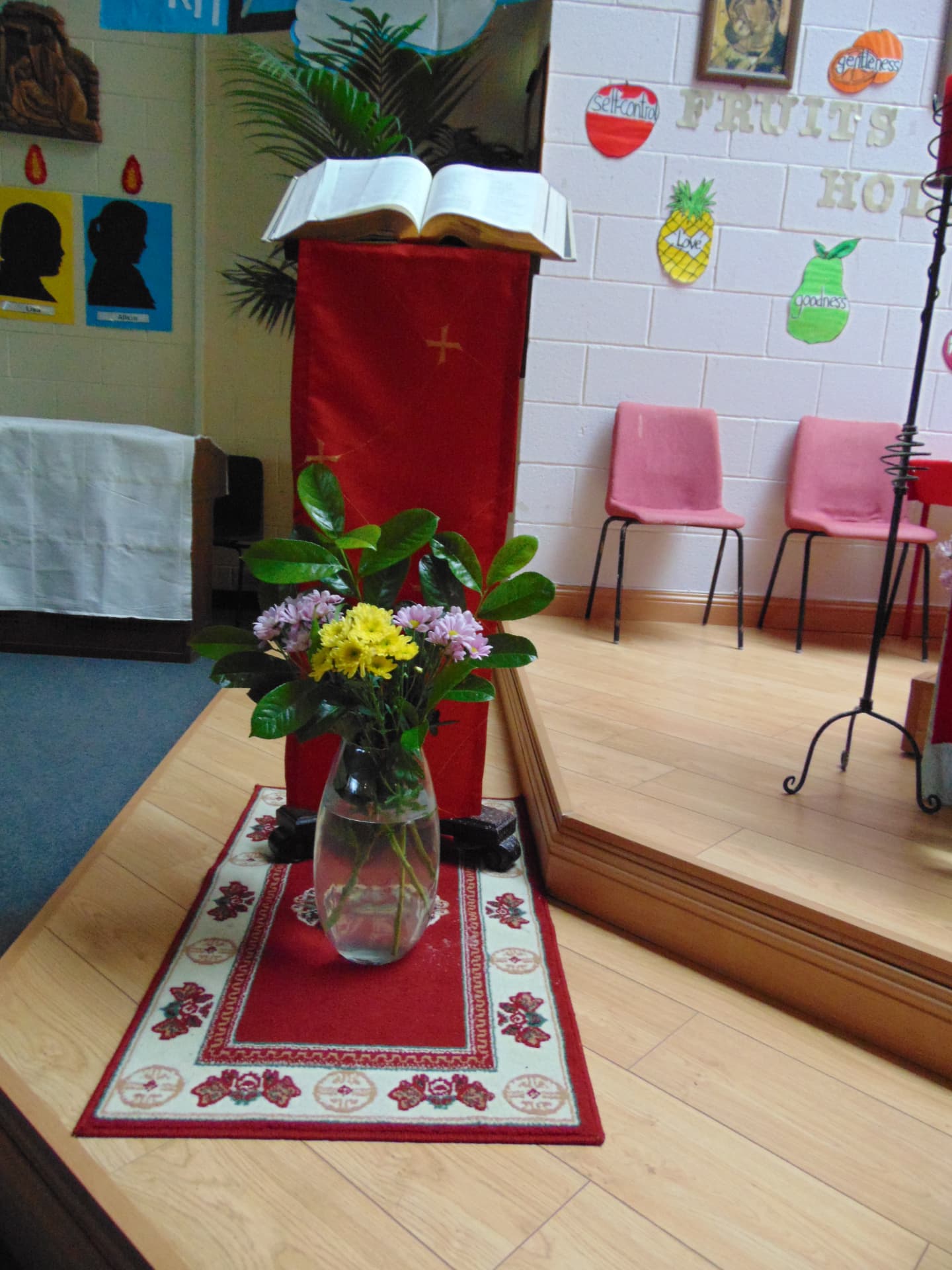 Lectern with an open Bible and a vase of flowers